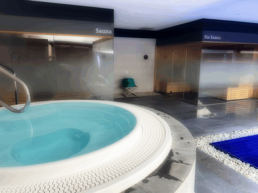 Jacuzzi og badstuer i bakgrunnen.