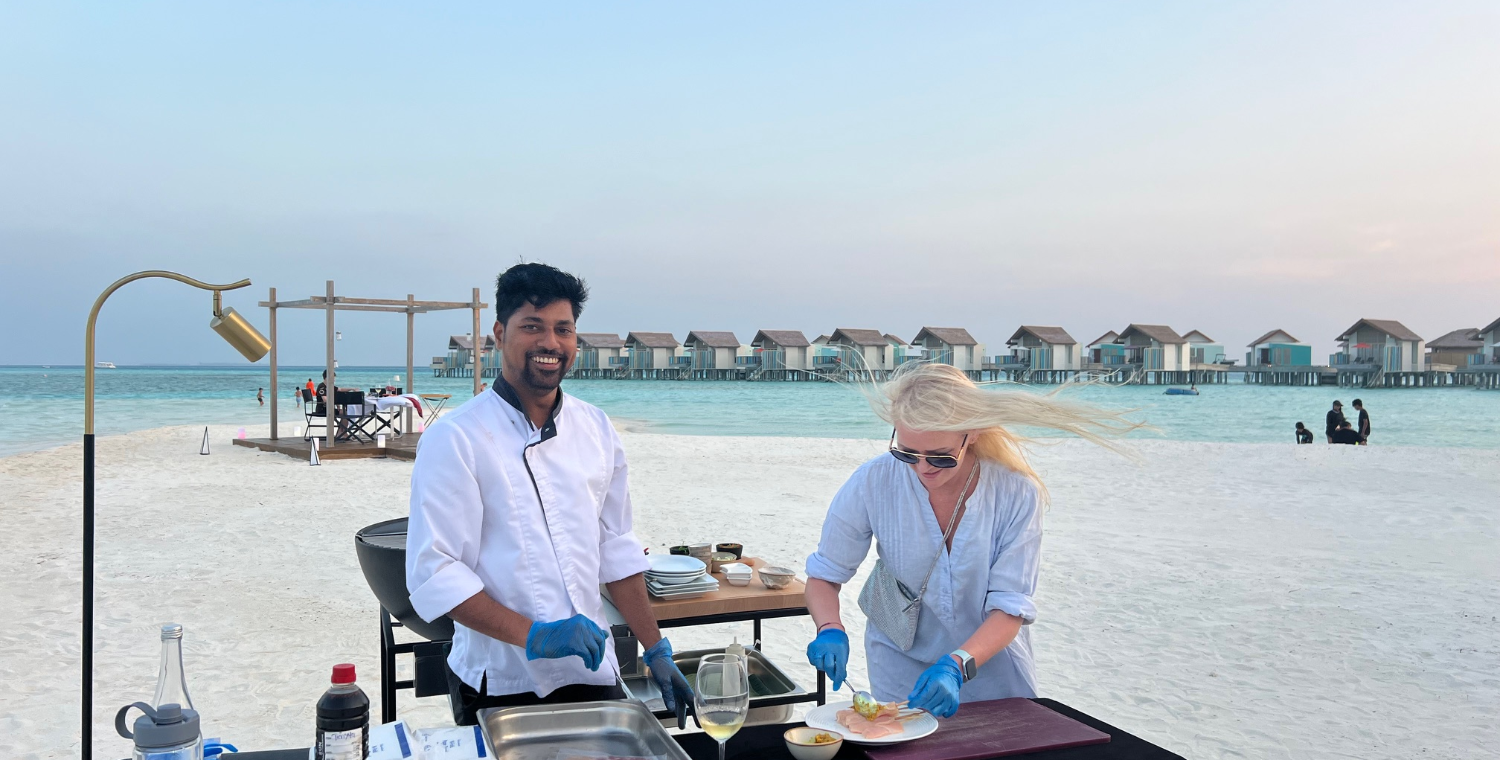 Kokk og Yvonne tilbereder mat på stranda.