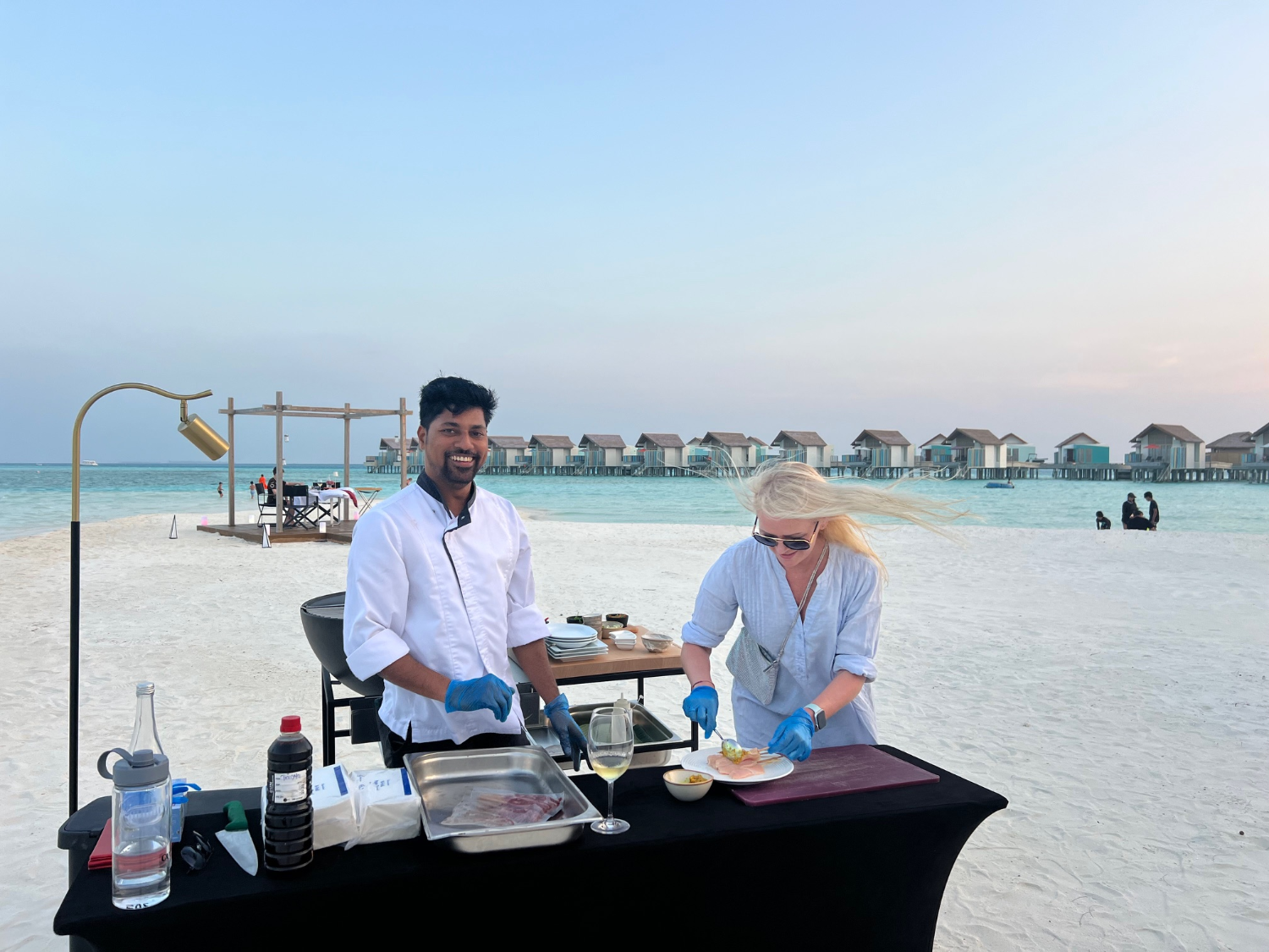 Kokk og Yvonne tilbereder mat på stranda.