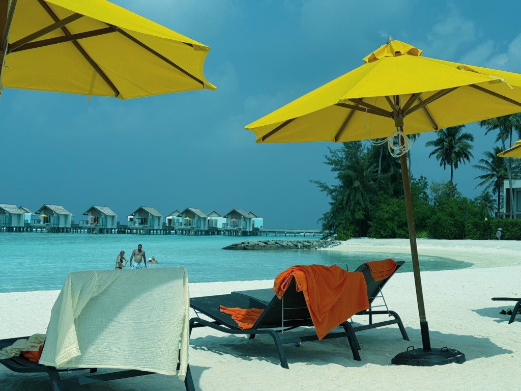 Parasoller og solsenger på stranda.